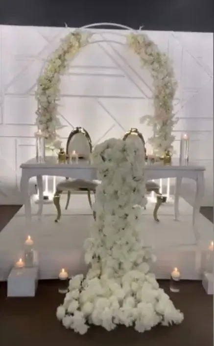 Arche blanche, table d’honneur et cascade florale sur scène blanche