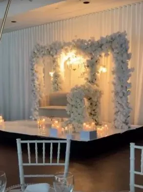 Arche de fleurs blanches illuminée, sofa et chaises Chiavari