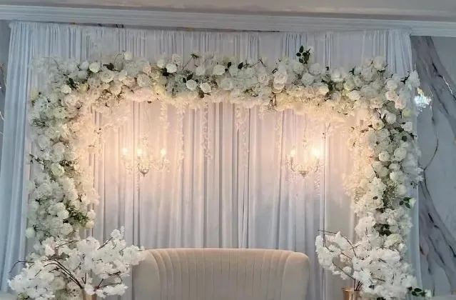 Arche florale blanche et sofa illuminés — décoration de mariage
