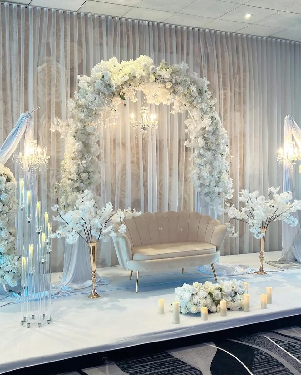 Arche florale blanche, sofa coquillage et chandeliers en cristal — vue rapprochée