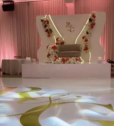 Backdrop lumineux R&G avec roses rouges et blanches, sofa et plancher de danse monogrammé