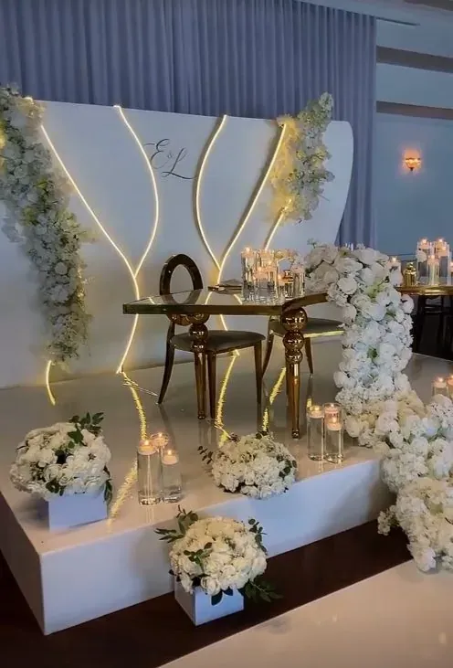 Backdrop lumineux, table d’honneur dorée et arrangements floraux blancs