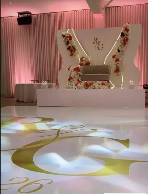 Backdrop R&G et plancher de danse avec monogramme doré, éclairage rose
