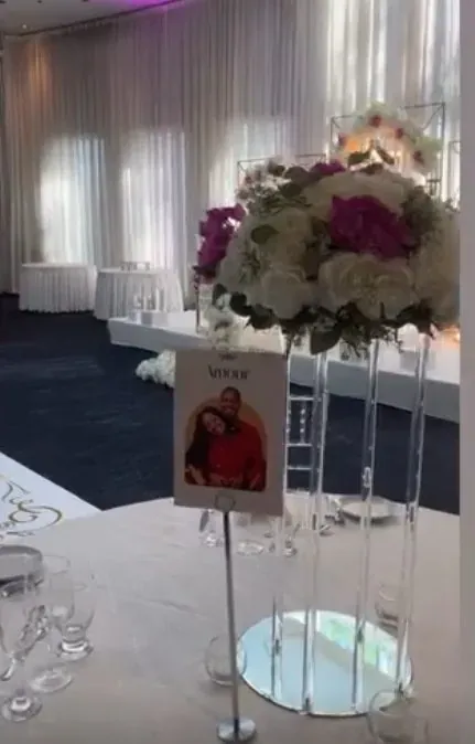 Centre de table haut aux fleurs blanches et bordeaux avec photo des mariés