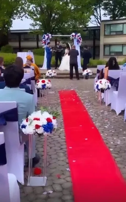 Cérémonie extérieure avec allée rouge et fleurs bleues, blanches et rouges