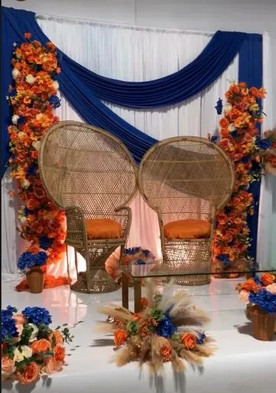 Cérémonie traditionnelle : fauteuils en rotin, draperie bleue et fleurs orangées
