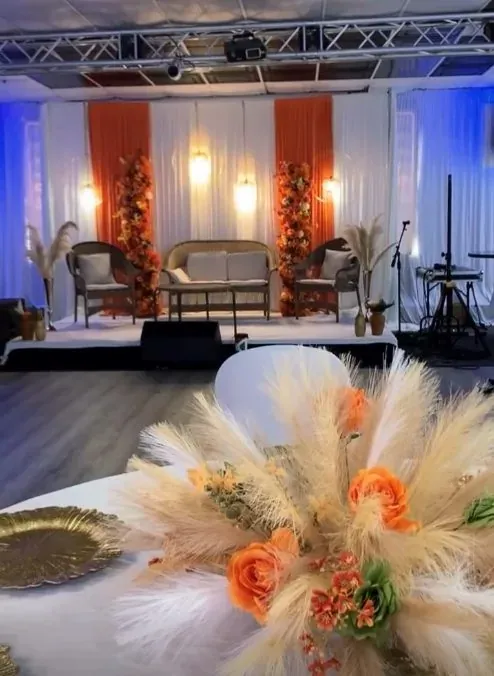 Décor de cérémonie avec fauteuils en rotin et bouquet de pampa au premier plan