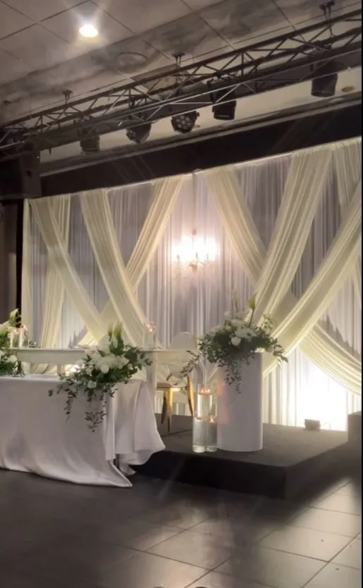 Draperie croisée ivoire et table d’honneur fleurie, vue de côté