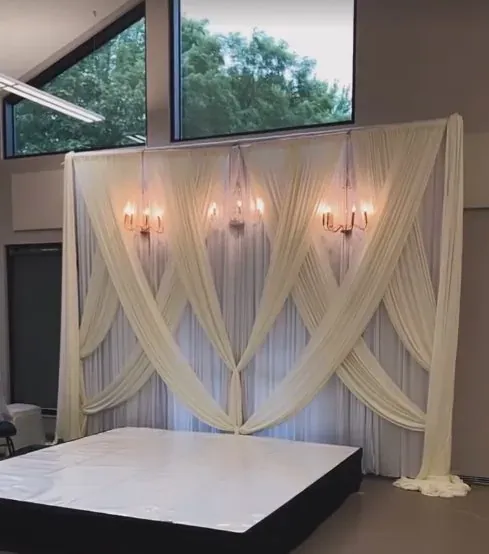 Draperie ivoire en vagues et estrade blanche dans une salle vitrée