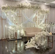Drapés croisés, guirlandes florales blanches, sofa et chandeliers en cristal