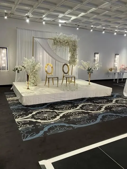 Estrade blanche avec drapé et chaises dorées — vue d’ensemble de la salle