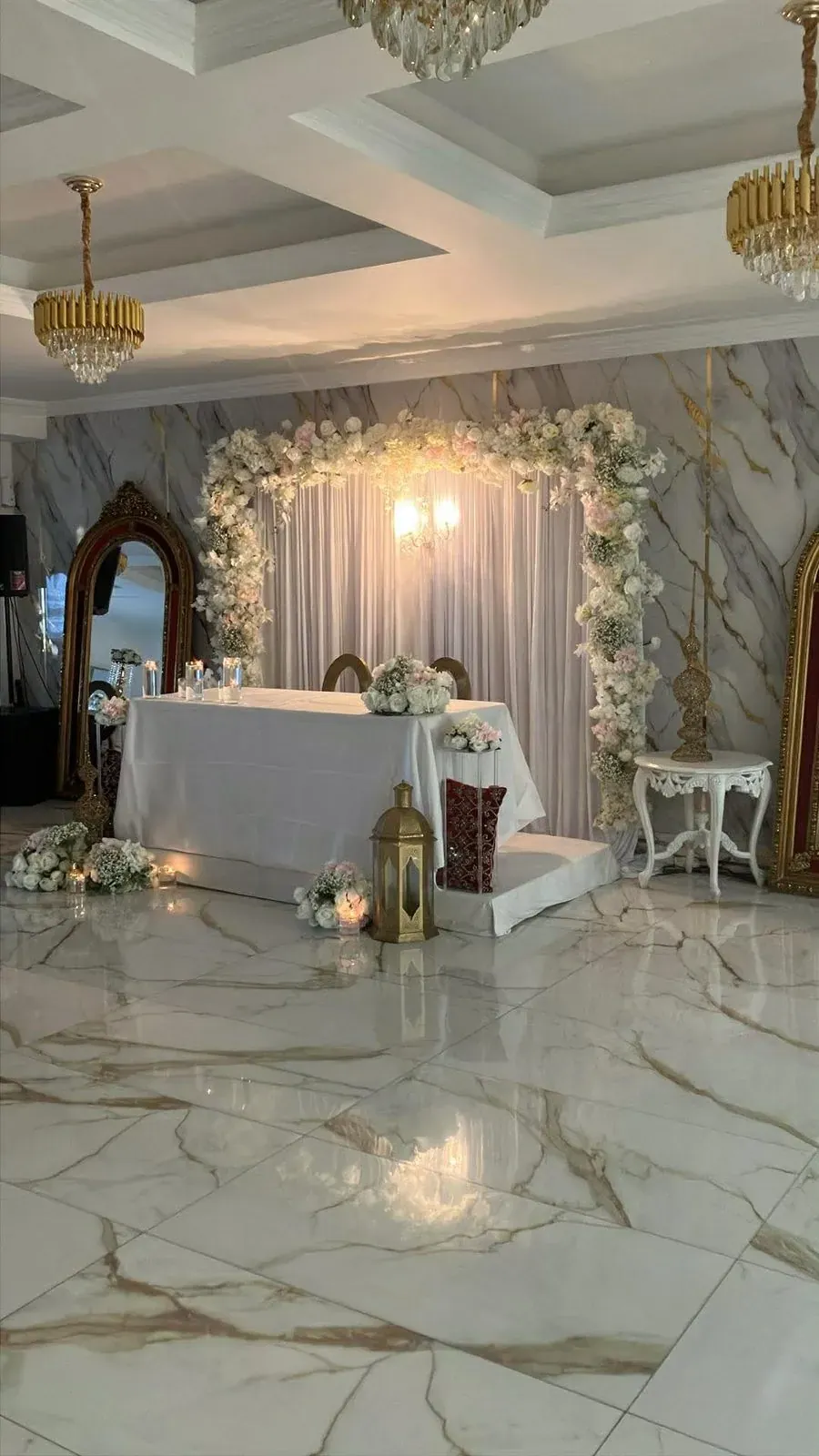 Fiançailles maghrébines : table des fiancés et arche florale dans une salle en marbre