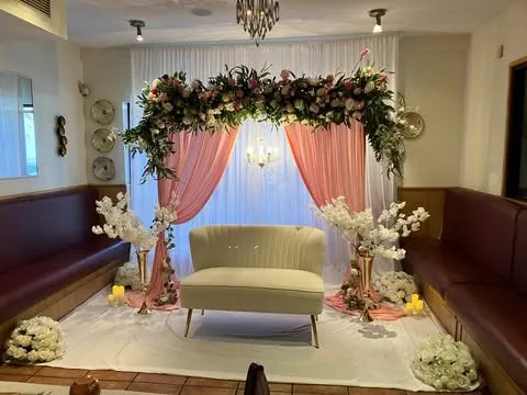 Guirlande florale rose et verte, voilages roses et sofa ivoire