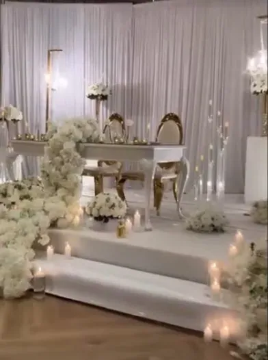 Scène à marches avec draperie blanche, cadres dorés et cascades de fleurs