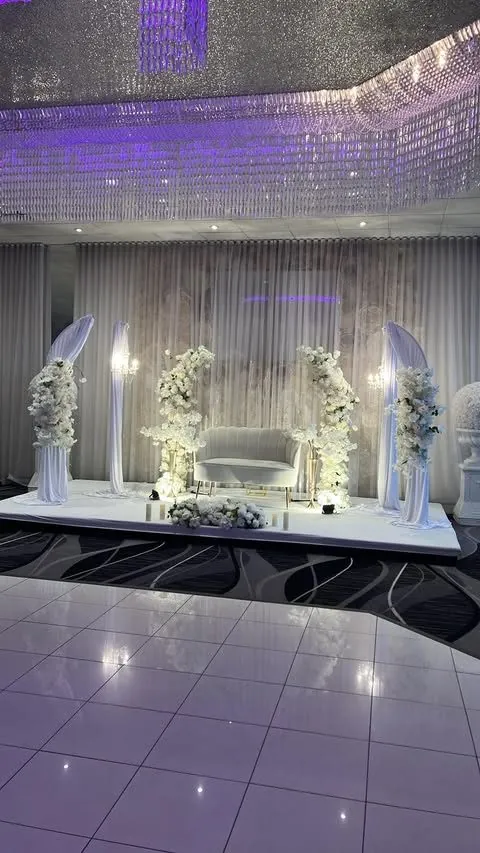 Scène blanche avec arches drapées et sofa, éclairage mauve