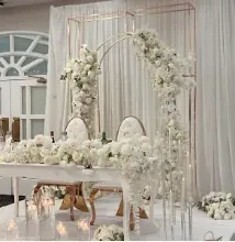 Table d’honneur sous des cadres dorés fleuris de blanc, chaises médaillon