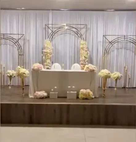 Table d’honneur sous trois arches dorées garnies de fleurs blanches