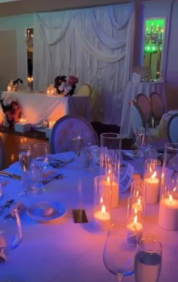 Tables de réception aux bougies sous éclairage mauve