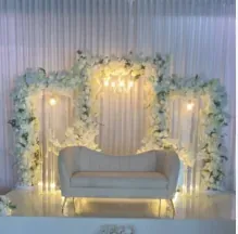 Trois arches de fleurs blanches illuminées et sofa ivoire
