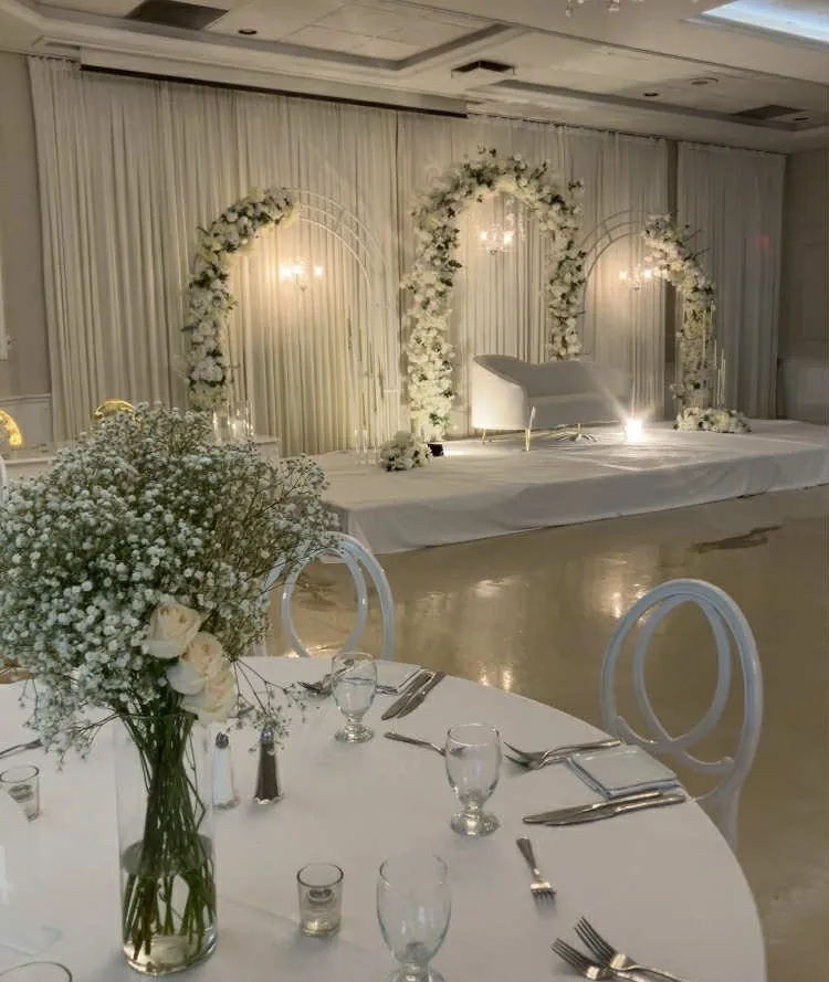 Trois arches florales blanches et scène des mariés, centre de table de gypsophile au premier plan